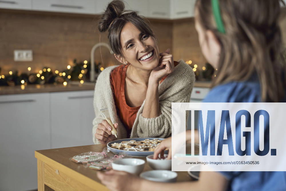 Happy woman with daughter decorating gingerbread cookie at home model released, Symbolfoto property released, ABIF01782
