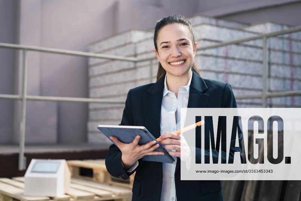 IMAGO Creative: Business, Inflation und Lieferketten Happy businesswoman with tablet computer at factory model released, Symbolfoto property released, JOSEF10514