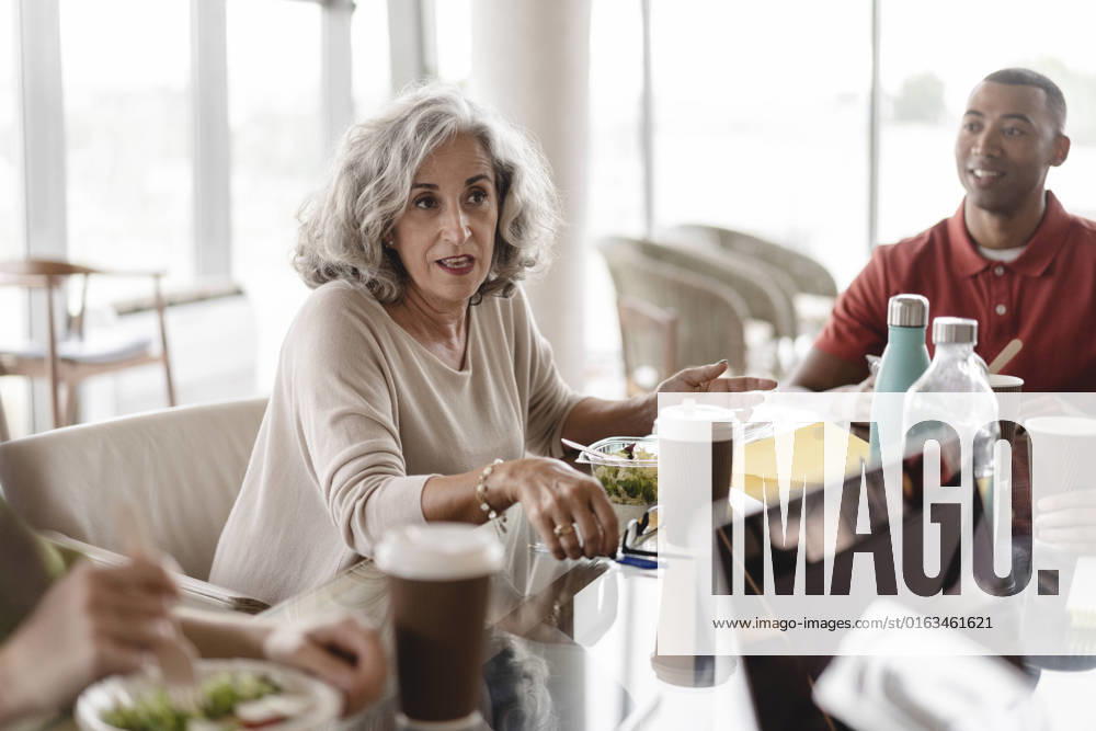 Senior businesswoman sitting with businessman discussing at table in office model released, Symbolfoto property released, JCICF00151