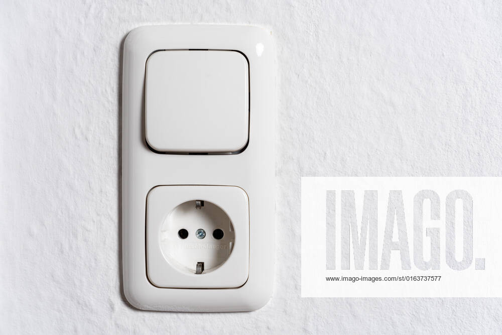 Light switch and socket on the wall of a room