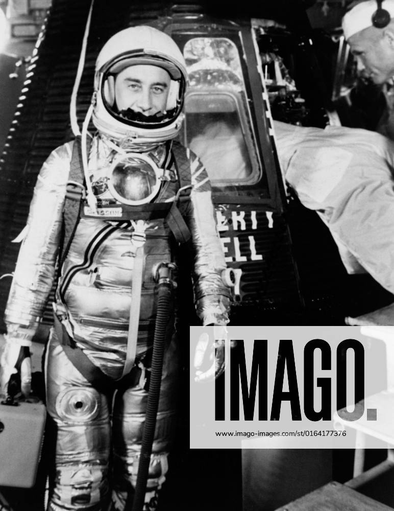 S61-02888 (1961) --- Astronaut Virgil I. (Gus) Grissom, suited up and ready to climb into Liberty Bell 7 spacecraft, stands in front of the capsule for a picture. Backup pilot John Glenn is in the right corner of the view behind Grissom. The Mercury-Redstone 4 (MR-4) mission was scrubbed a few hours later due to unfavorable weather over the launch pad.