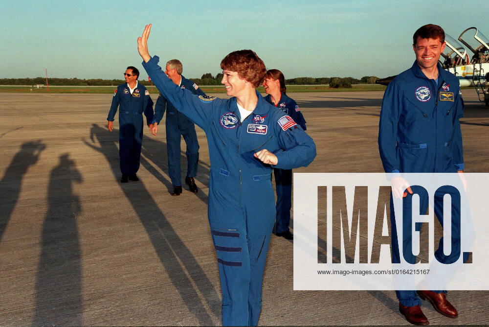 The STS-93 crew leave the Shuttle Landing Facility after answering questions for the media and posing for photographers, whose shadows stretch across the SLF. From left are Mission Specialists Michel Tognini of France, who is with the Centre National d Etudes Spatiales (CNES) and Steven A. Hawley (Ph.D.), Commander Eileen M. Collins (waving), Mission Specialist Catherine G. Cady Coleman (Ph.D.), and Pilot Jeffrey S. Ashby. The crew arrived at KSC for pre-launch activities. Collins is the first woman to serve as mission commander. The primary mission of STS-93 is the release of the Chandra X-ray Observatory, which will allow scientists from around the world to study some of the most distant, powerful and dynamic objects in the universe. Th