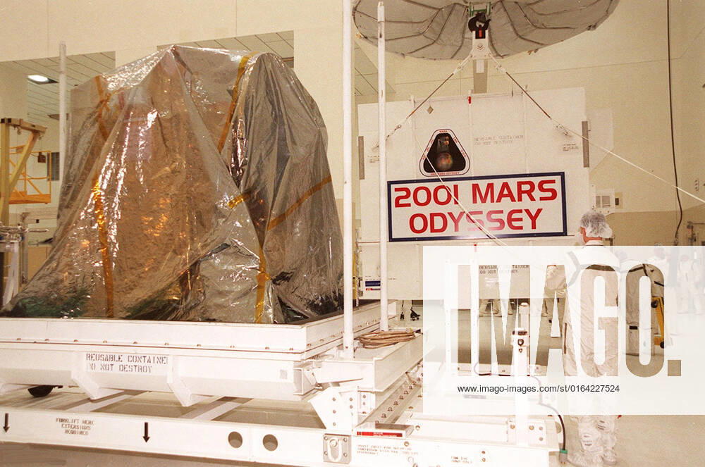 Workers in the Spacecraft Assembly and Encapsulation Facility 2 move the shipping crate away from the 2001 Mars Odyssey spacecraft, at left on the stand. Odyssey is still covered by a protective sheet. The spacecraft, which arrived from Denver, Colo., Jan. 4, will undergo final assembly and checkout in the SAEF-2. That includes installation of two of the three science instruments, integration of the three-panel solar array, and a spacecraft functional test. Launch aboard a Boeing Delta II launch vehicle from Pad A, Complex 17, CCAFS, is planned for April 7, 2001 the first day of a 21-day planetary window. The spacecraft will arrive at Mars on Oct. 20, 2001, for insertion into an initial elliptical capture orbit. Its final operational altitu