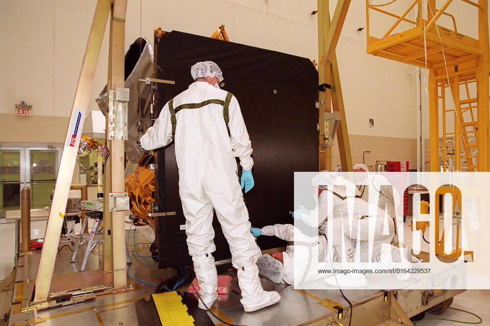 Workers in the Spacecraft Assembly and Encapsulation Facility (SAEF 2) reattach the solar panel on the 2001 Mars Odyssey Orbiter in order to conduct illumination testing. Scheduled for launch April 7, 2001, the orbiter contains three science instruments: THEMIS, the Gamma Ray Spectrometer (GRS), and the Mars Radiation Environment Experiment (MARIE). THEMIS will map the mineralogy and morphology of the Martian surface using a high-resolution camera and a thermal infrared imaging spectrometer. The GRS will achieve global mapping of the elemental composition of the surface and determine the abundance of hydrogen in the shallow subsurface. The MARIE will characterize aspects of the near-space radiation environment with regards to the radiation-