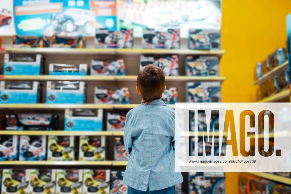 Little boy at the shelf in kids store, back view, Little boy at the shelf in kids store, back view. Son choosing toys in supermarket, family shopping, Little boy at the shelf in kids store, back view. Son choosing toys in supermarket, family shopping model released, Symbolfoto , 05.02.2020,
