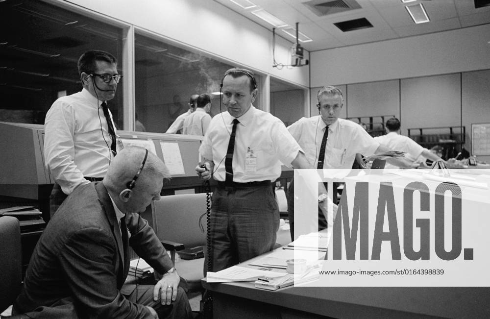 S65-62062 (12 Dec. 1965) --- Discussing the scrubbing of the planned National Aeronautics and Space Administration s Gemini-6 spaceflight are (from left) William C. Schneider (standing), deputy director, Gemini Program Office of Manned Spaceflight, NASA Headquarters, Washington, D.C.; Eugene F. Kranz (seated), white team flight director; Christopher C. Kraft Jr., red team flight director; and John D. Hodge, blue team flight director. The Gemini-6 mission has been rescheduled for Dec. 15, 1965.