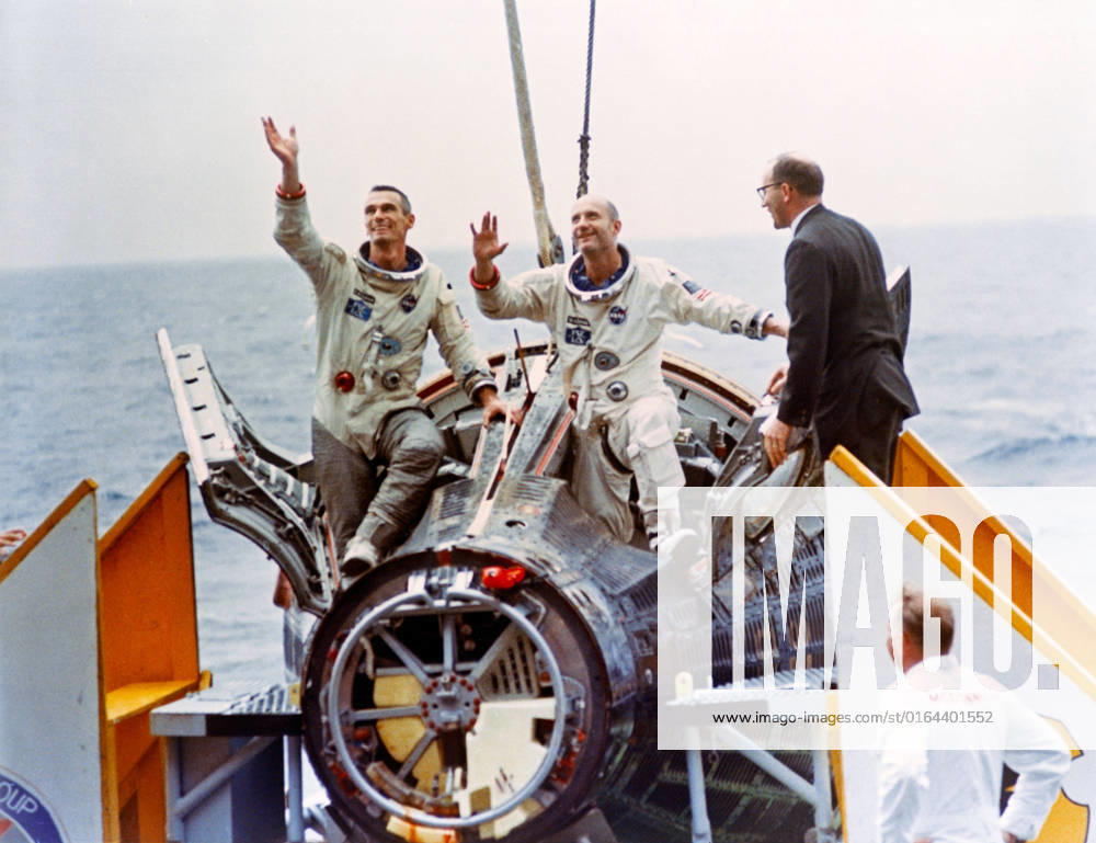S66-34118 (6 June 1966) --- Astronauts Thomas Stafford (right) and Eugene Cernan wave to the crowd aboard the aircraft carrier USS Wasp as they emerge from their Gemini-9 capsule. John C. Stonesifer (far right), with the Manned Spacecraft Center s Landing and Recovery Division, was onboard to greet the astronauts.