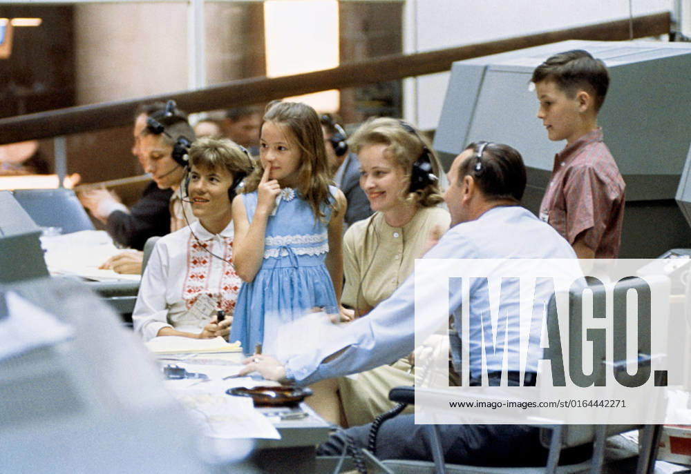 S65-30411 (9 June 1965) --- The families of Gemini 4 astronauts James A. McDivitt and Edward H. White II visited the Mission Control Center in Houston. In the foreground, left to right, are Mrs. Patricia McDivitt, daughter Bonnie White, Mrs. Patricia White, flight director Christopher C. Kraft Jr., and Edward White III. Each of the family members talked with the astronauts as they passed over the United States.