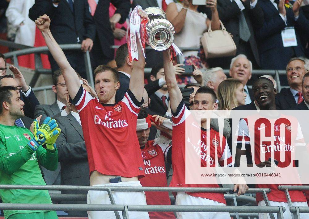 Football - 2014 FA Cup Final - Arsenal FC vs. Hull City Arsenal s Per Mertesacker and Laurent Koscielny lift the trophy at Wembley.