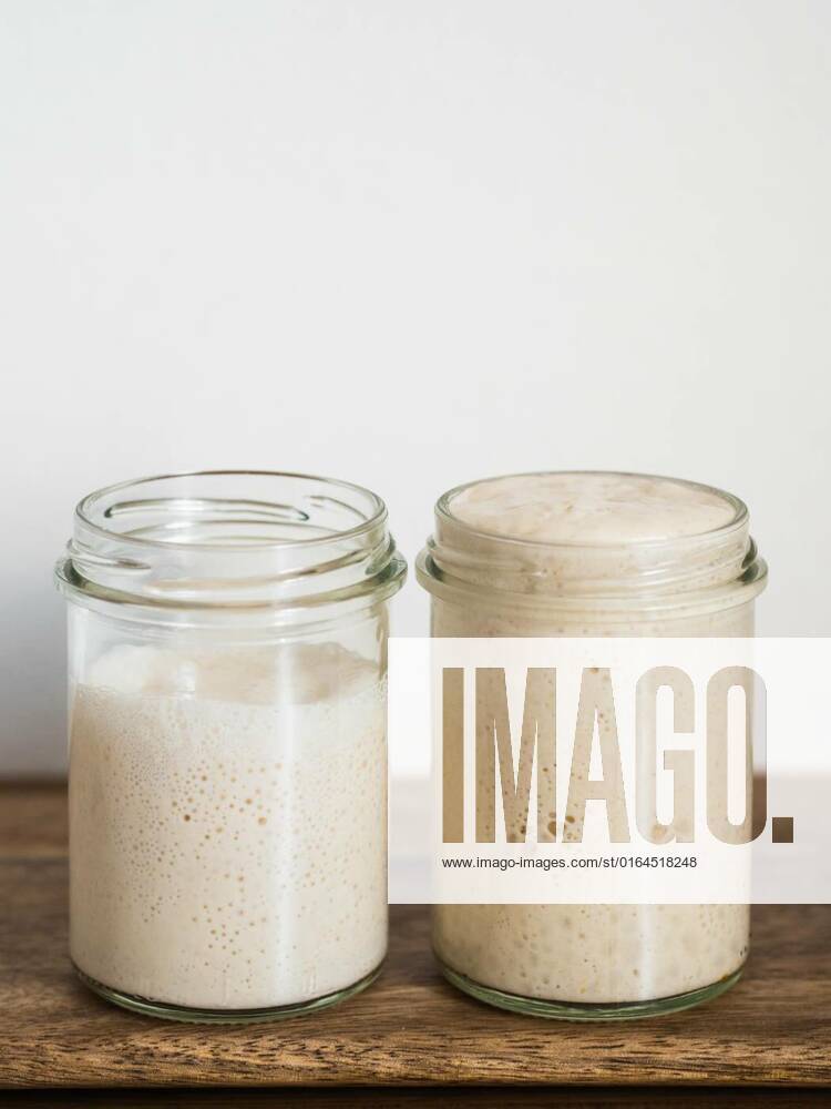Wheat sourdough starter different hydration levels, Two glass jars with wheat sourdough starters in different hydration levels. Starter 100 percent hydration (right) and starter with higher hydration (left). Copy space top. Vertical., Two glass jars with wheat sourdough starters in different hydration levels. Starter 100 percent hydration (right) and starter with higher hydration (left). Copy space top. Vertical., 17.05.2020,