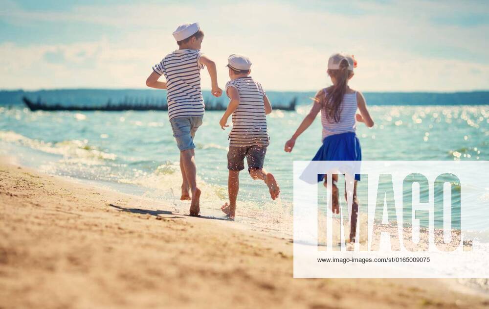 Babygirl and babyboy sitting on the beach, children jumping on the beach in summer hats. Boys and girl having fun at seaside, children jumping on the beach in summer hats. Boys and girl having fun at seaside model released, Symbolfoto , 31.10.2020,