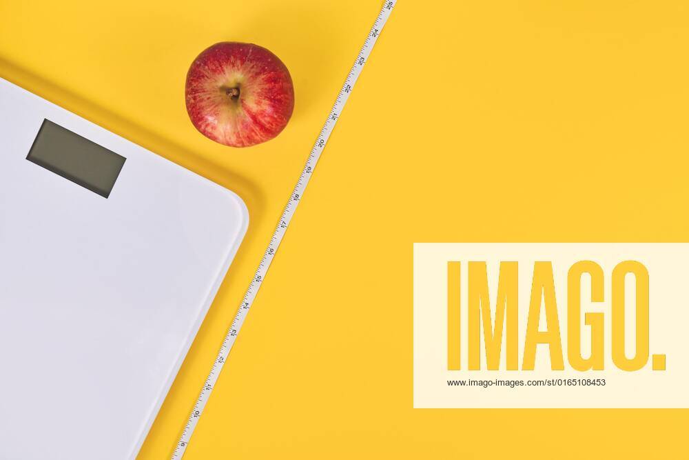 Diet Concept with Scale, Measuring tape and Apple at yellow Background with Copy Room