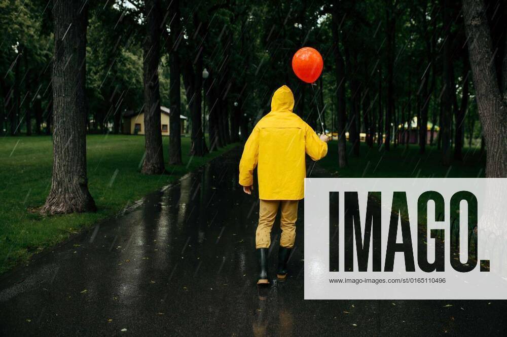 IMAGO Creative: Ende des Sommers Sad man with balloon walking in park in rainy day, Sad man with balloon walking in summer park in rainy day. Male person in rain cape and rubber boots, wet weather in alley, loneliness, Sad man with balloon walking in summer park in rainy day. Male person in rain cape and rubber boots, wet weather in alley, loneliness, 06.09.2020,