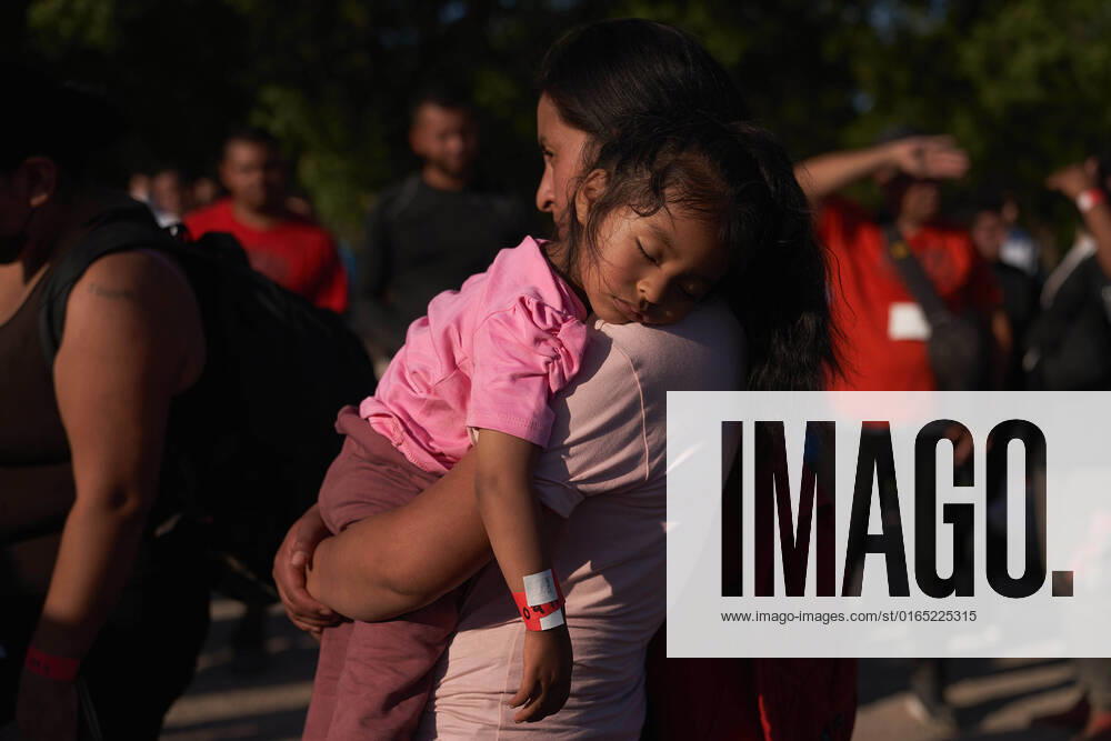 A woman holds a child as migrants, part of a group of over 200, are processed by U.S. Border Patrol after illegally crossing the Rio Grande River from Mexico into Normandy, Texas on Thursday. Normandy USA - ZUMAd211 20220811_zap_d211_013