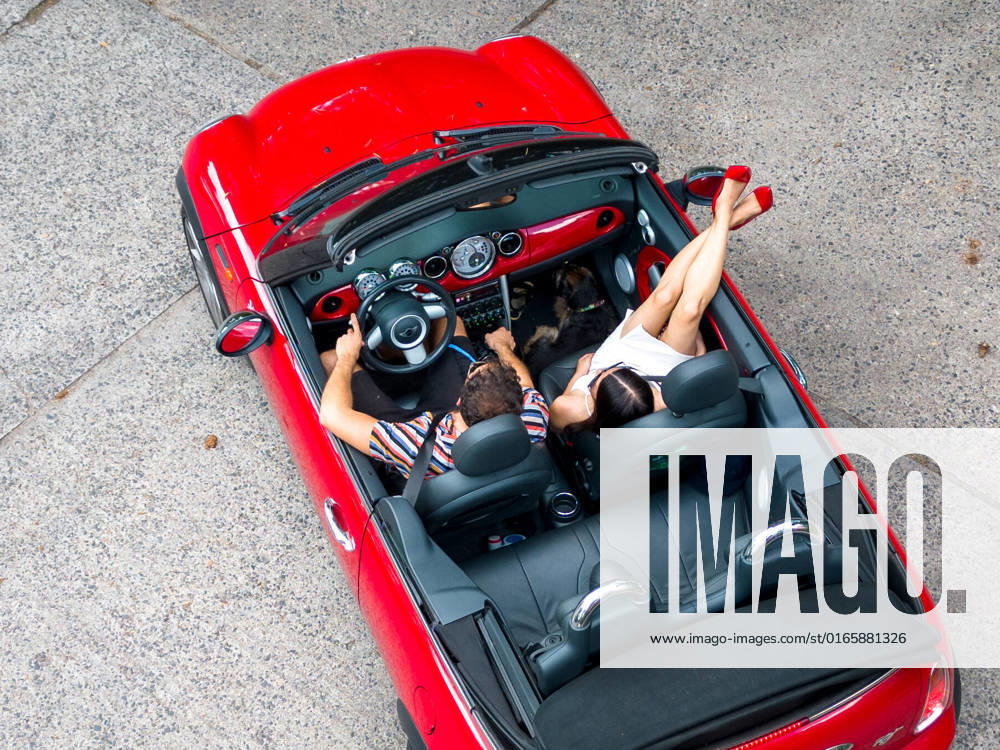 Sommer in Berlin - Cabrio fahren - CREATIVE Berlin, Deutschland - 16. August 2022: (CREATIVE) Ein Paar (junger Mann und junge Frau) geniessen den Sommer in einem BMW Mini Cabriolet. (Photo: Christian Ender) Berlin
