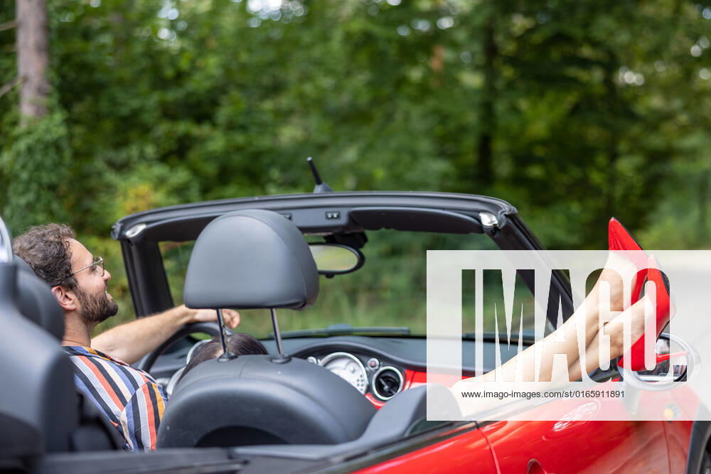 Sommer in Berlin - Cabrio fahren - CREATIVE Berlin, Deutschland - 16. August 2022: (CREATIVE) Ein Paar (junger Mann und junge Frau) geniessen den Sommer in einem Cabriolet. (Photo: Christian Ender) Berlin