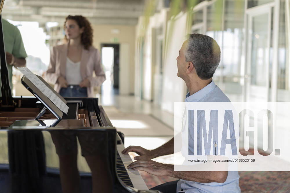 Businessman practicing piano sitting in office model released, Symbolfoto property released, JCICF00384