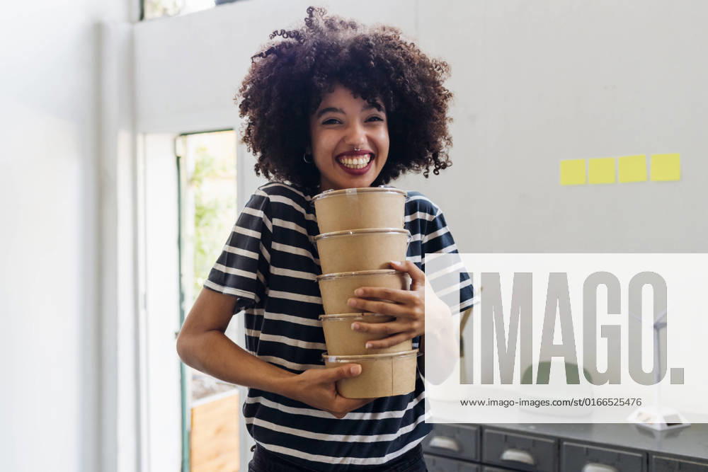Happy businesswoman holding lunch boxes in office model released, Symbolfoto property released, MEUF07114