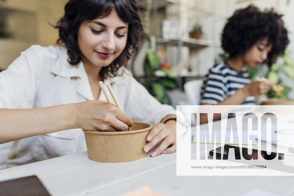 Businesswoman having food with chopsticks in lunch break at office model released, Symbolfoto property released, MEUF07130