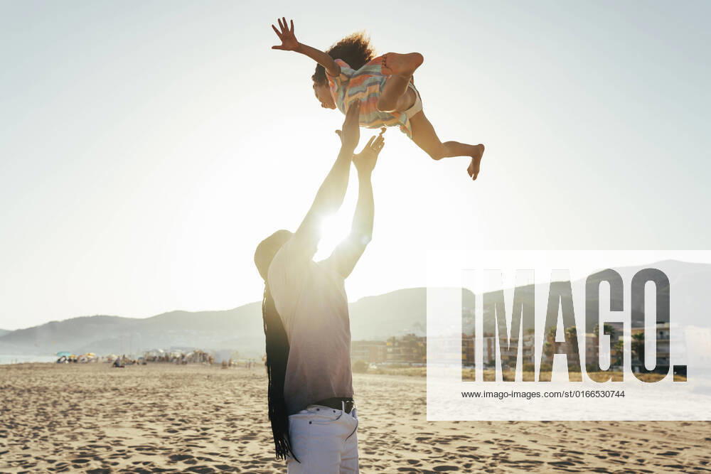 Playful father throwing daughter in air at beach model released, Symbolfoto, OIPF02120