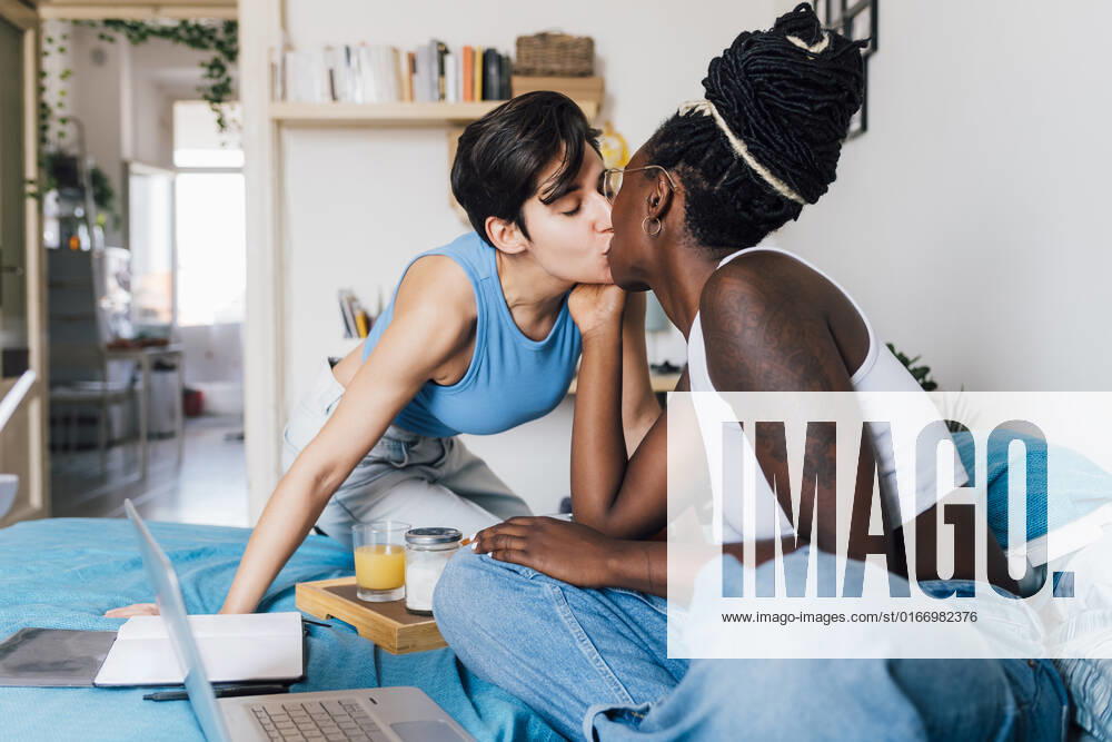Lesbian couple kissing each other on bed at home model released, Symbolfoto property released, MEUF07870
