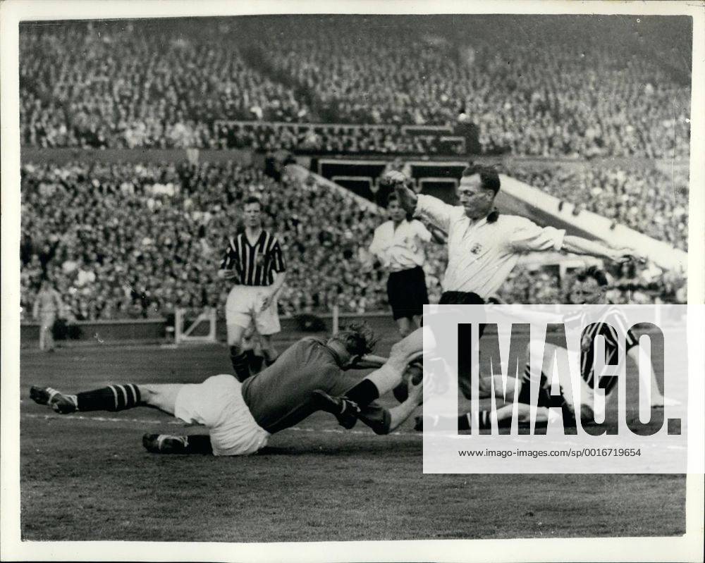 MANCHESTER CITY WINS THE F.A. Cup Photo shows: Manchester City goalkeeper, Bert Trautmann, dives at the feet of The Birmingham City inside-right, Peter Murphy during the F.A. Cup Final at London, Wembley today. Trautmann, who was recently elected Footballer of the Year, was given a great ovation by the huge crowd, after the match. During the closing stages of the game he sustained a neck injury, which unsteadied him for a while, but he still carried on playing. Manchester City won by 3-1. - ZUMAk09