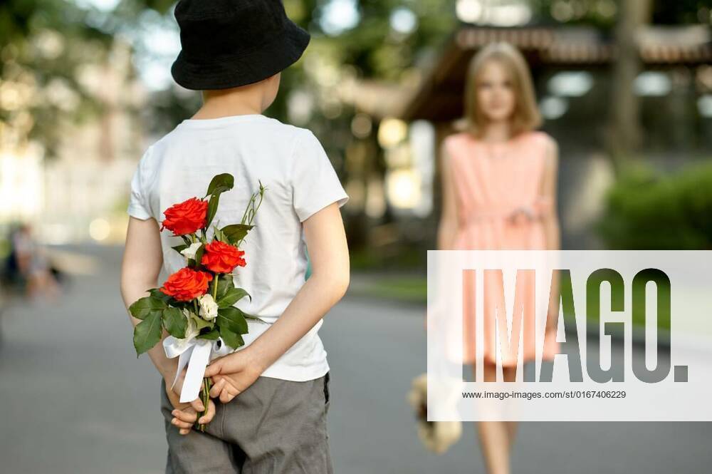 IMAGO Creative, Jahreszeit Sommer, Sommerferien Children s date, boy hides flowers from a girl, Children s romantic date in summer park, friendship, first love. Boy hides flowers from a girl. Kids having fun outdoors, happy childhood, Children s romantic date in summer park, friendship, first love. Boy hides flowers from a girl. Kids having fun outdoors, happy childhood, 27.09.2021,