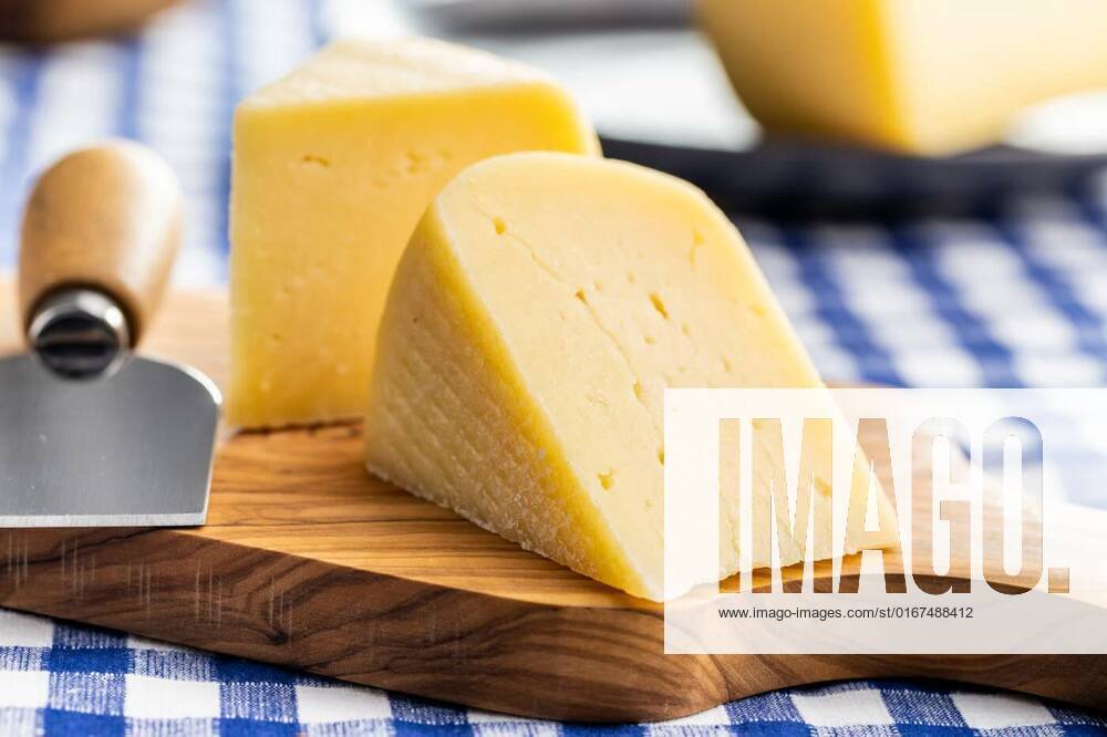 Block of hard cheese. Sliced cheese., Block of hard cheese. Sliced cheese on cutting board., Block of hard cheese. Sliced cheese on cutting board., 15.10.2021,