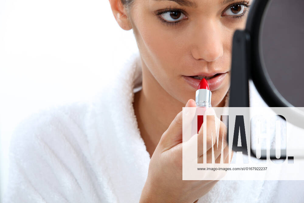 Woman applying lipstick in front of mirror, model released, , 4295173.jpg, 20s, anti-aging, appearance, applying, background, bathroom, beauty, conceal, conceitedness, concentrating, cosmetics, cream, dressing gown, e, elegance, fashion, front view, getting ready, hair, landscape, lips, lipstick, make-up, mirror, moisturizer, morning, mouth, narcissism, ponytail, preparing, pride, products, red, robe, routine, skin, style, tied-up, vain, vanity, white,