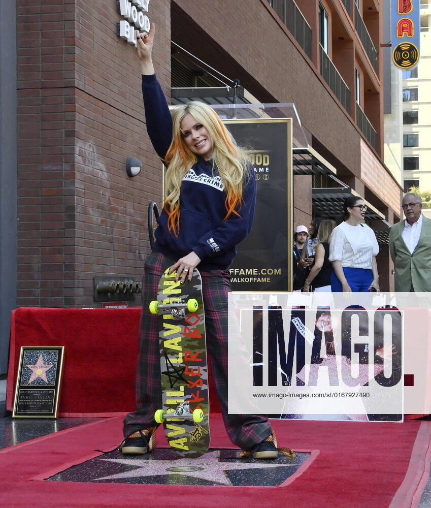 Canadian award winning singer and songwriter Avril Lavigne strikes a poser during an unveiling ceremony honoring her with the 2,731st star on the Hollywood Walk of Fame in Los Angeles on Wednesday, August 31, 2022. Behind her is an enlarged photo of her at 16 when she first arrived in Hollywood posing next to a star on the famous landmark. LAP2022083105 JIMxRUYMEN