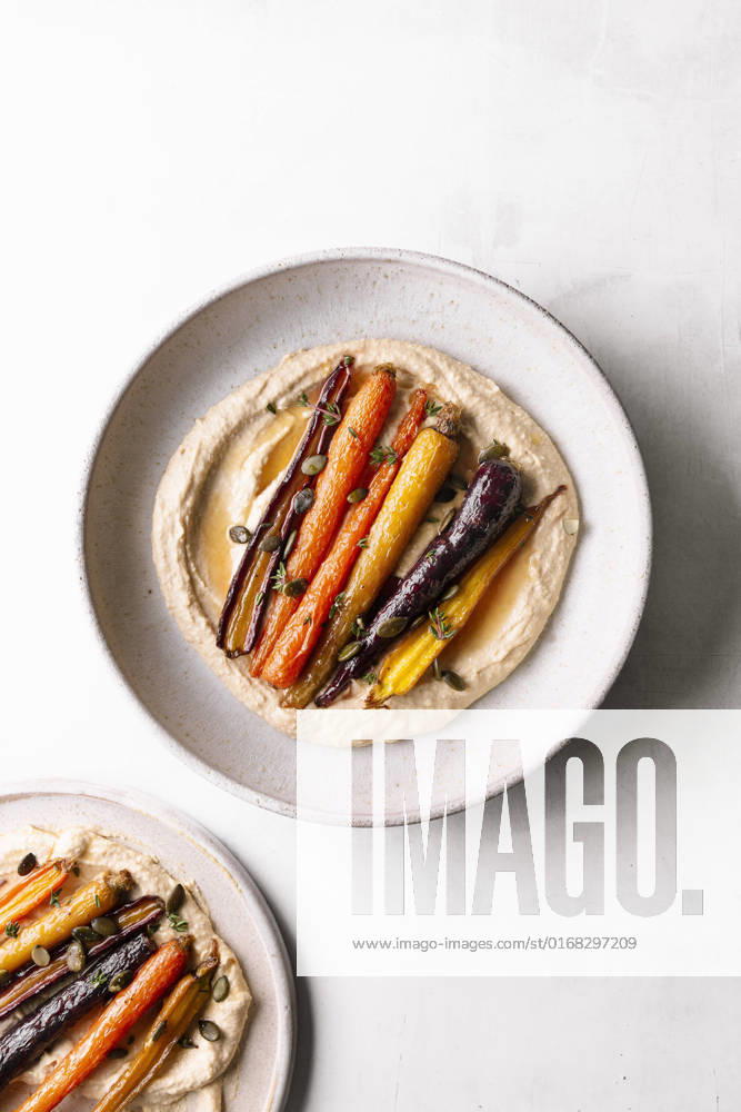 IMAGO Creative, Food, Hummus Honey roasted carrots with hummus in a ceramic bowl. Honey roasted carrots with hummus in a ceramic bowl.