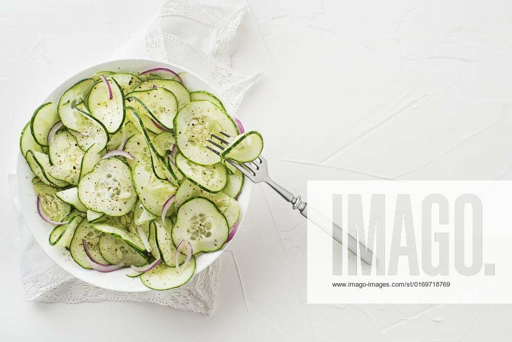 IMAGO Creative, Food, Gurkensalat Cucumber salad, Cucumber salad with onion and dressing on white table background, Cucumber salad with onion and dressing on white table background, 03.09.2022,