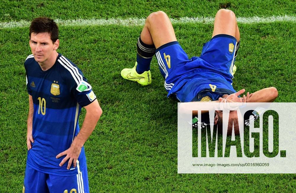 Rio De Janeiro, BRAZIL - Argentina s Pablo Zabaleta lies on the pitch as Lionel Messi stands beside him after the World Cup final soccer match between Germany and Argentina at the Maracana Stadium in Rio de Janeiro, Brazil, Sunday, July 13, 2014. Germany defeats Argentina 1-0. - ZUMAp12