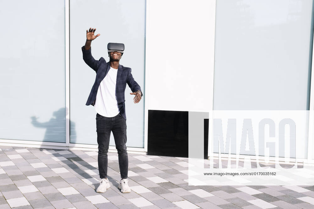 Man with virtual reality simulator gesturing in front of wall model released, Symbolfoto, AMWF00322