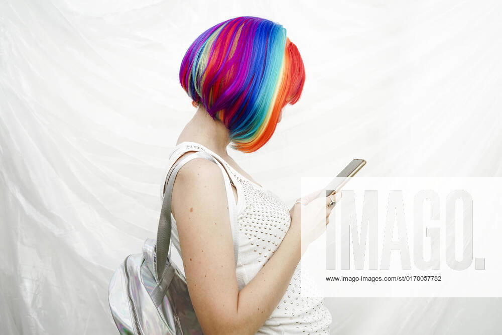 IMAGO Creative: Business, Innovative Technologie-Lösungen Woman with multi colored hair using smart phone by plastic backdrop model released, Symbolfoto, SVCF00141