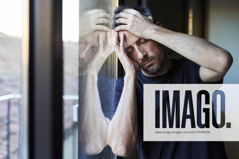 Depressed man with eyes closed leaning on window model released, Symbolfoto property released, VEGF05867