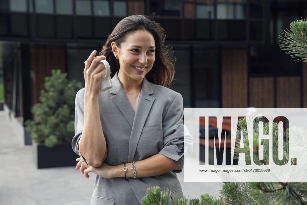 Happy beautiful businesswoman with coffee mug at office park model released, Symbolfoto, VPIF07127