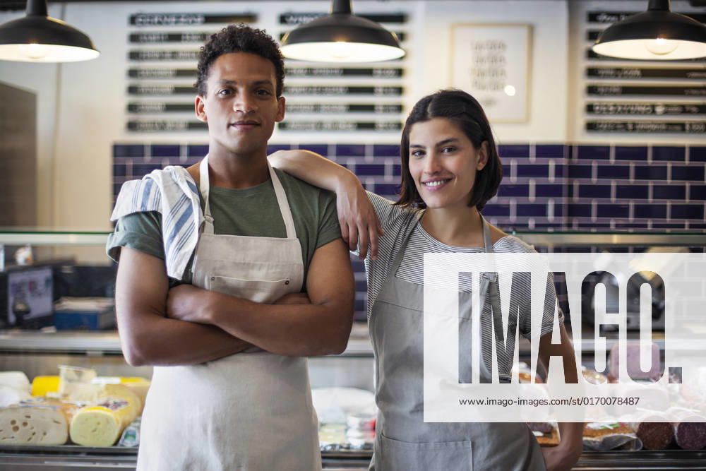 IMAGO Creative: Business, Inflation und Lieferketten Confident grocery store owners looking at the camera while standing indoors
