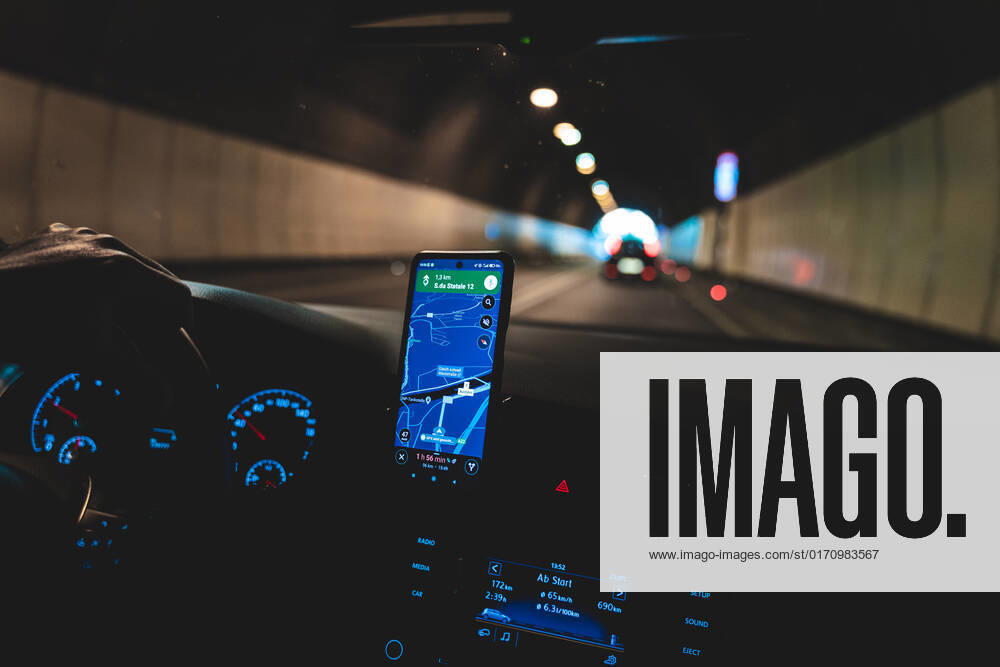 Navigation with a smartphone in a car using the Google Maps app. Driving in the dark through a tunnel, navi app icon image