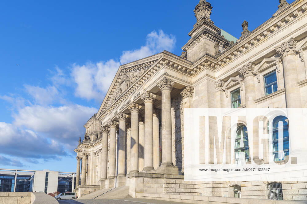 Symbolic image German Bundestag Germany, Berlin, Bundestag frog perspective side view from sunlit portal of the Reichstag building DEM DEUTSCHEN VOLKE , blue sky with white clouds in the background Laterally Paul Löbe Haus