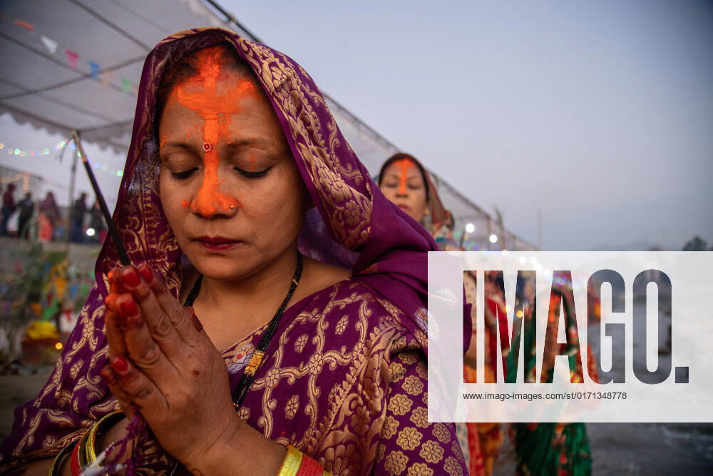 Chhath concludes in Nepal with offering to rising sun Fasting Nepali Hindu women prays to rising Sun holding incense sticks on her hand as she performs rituals on edge of the Bagmati river waiting for the sunrise to make final offering to the rising Sun considered as god in Hindu Mythology in Lalitpur District of Nepal on the final day of Chhath Festival. Nepali Hindu womens fast for 3 complete days and break the fasting on the fourth day of the Chhath festival where the rising and setting sun is worshipped and offered various offerings. This festival also is celebrated in the neighboring India. Lalitpur Bagmati Nepal