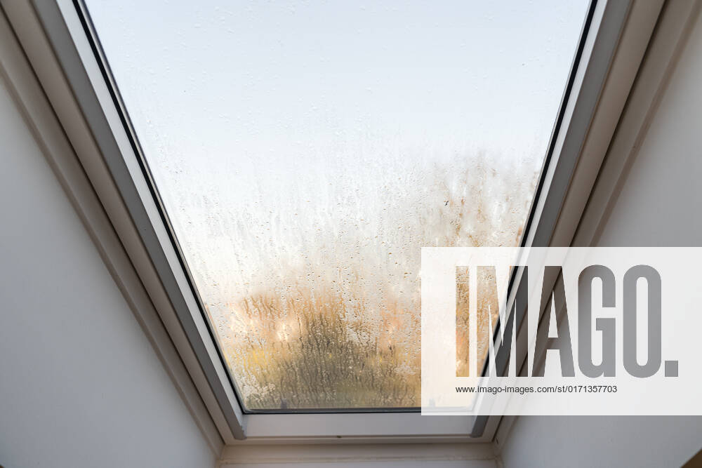 Germany, Bavaria - 31 October 2022: Fogged skylight in the morning. Water drops from condensation on a window