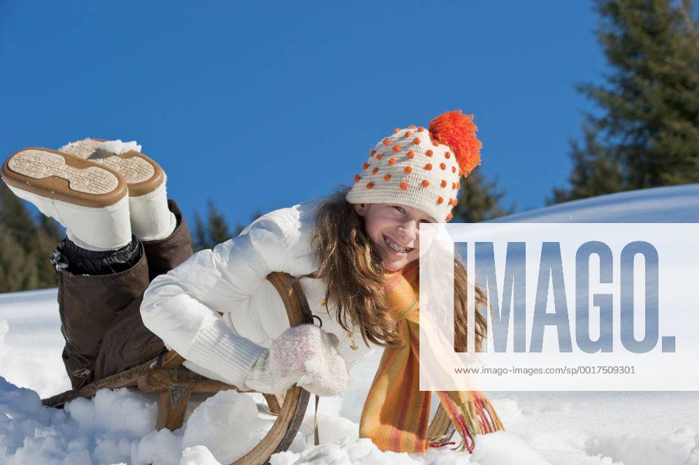 Austria, Salzburger Land, Altenmarkt, Girl (10-11) on sled, smiling, portrait model released HHF03004