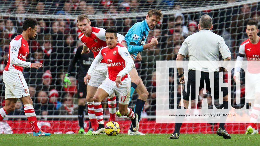 Football - 2014 2015 - Barclays Premier League, - Arsenal Vs Stoke City, Arsenal s Alexis Sanchez nips in front of Stoke City s Peter Crouch and Arsenal s Per Mertesacker to steal the ball at The Emirates Stadium ARS_STO
