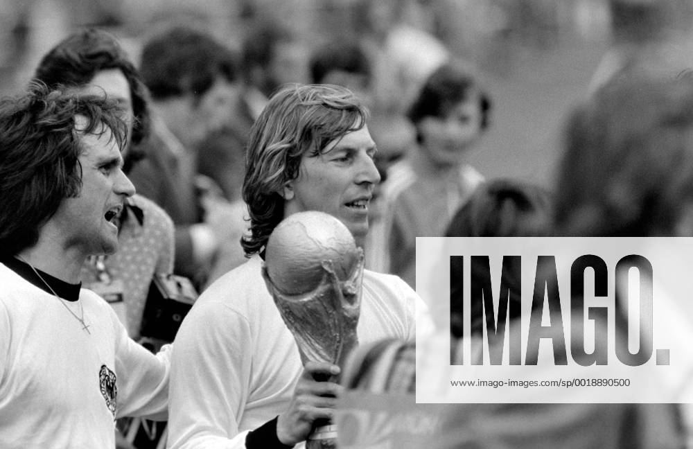 Fussball Weltmeisterschaft 1974 Finale Deutschland - Holland 07.07.1974 Deutschland ist Weltmeister; Juergen Grabowski (Mitte) jubelt mit dem WM-Pokal, Wolfgang Overath (li) MODELxRELEASExx