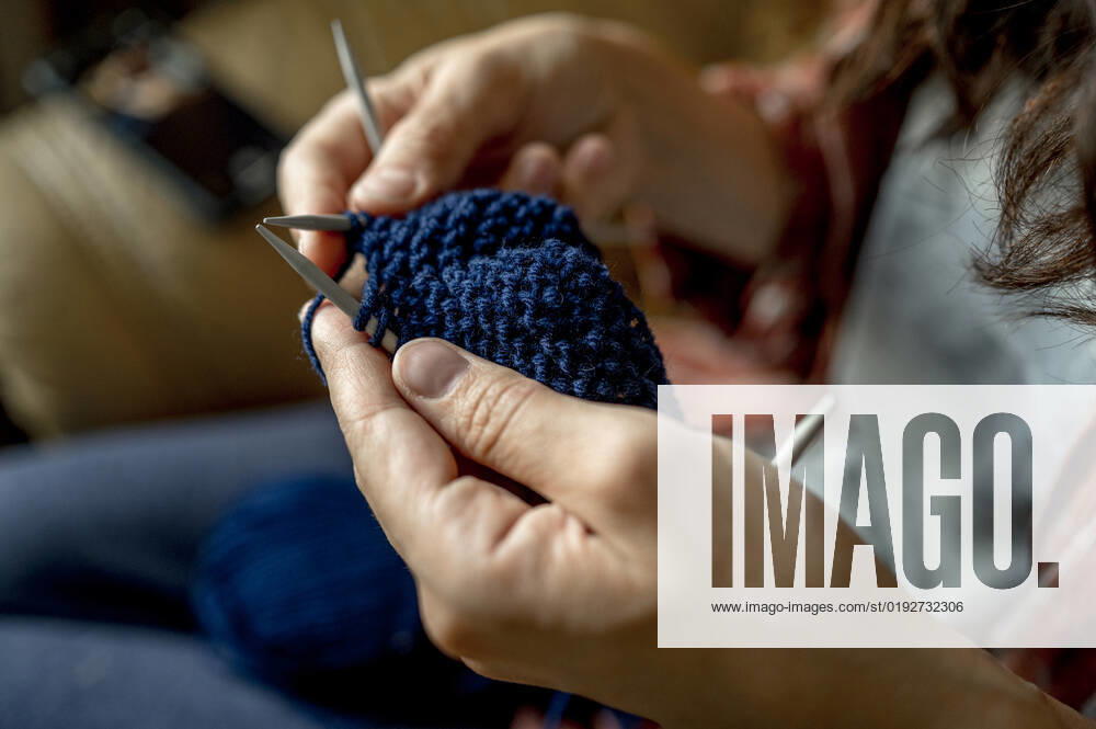 Woman knitting with blue wool at home model released, Symbolfoto, ANAF00099