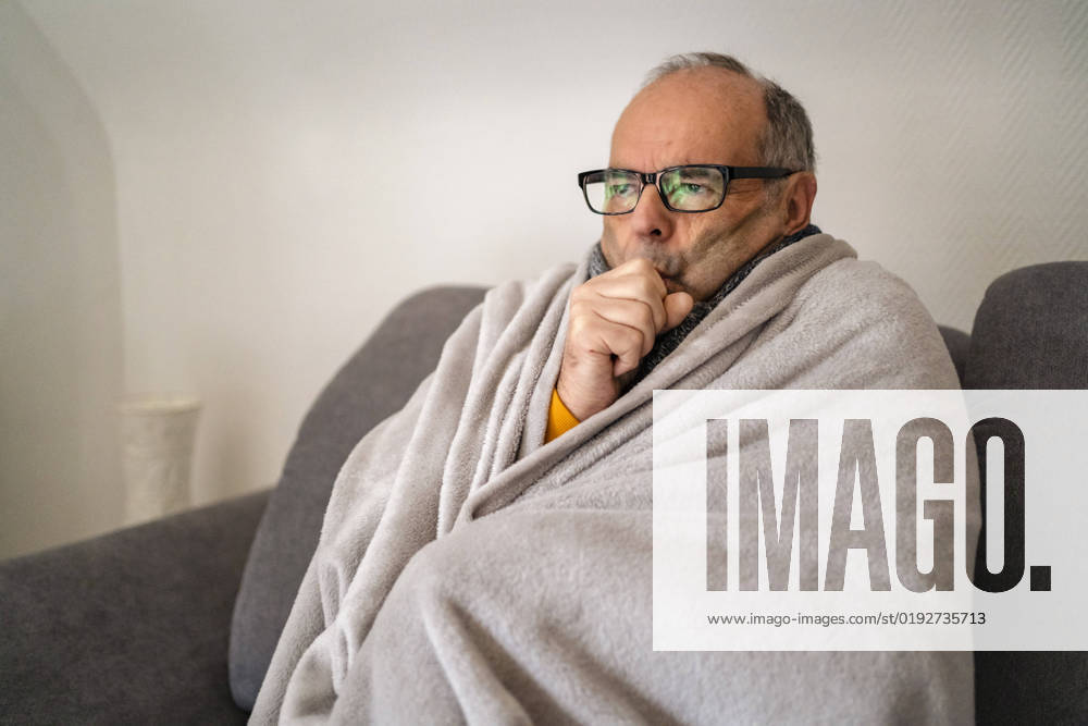 Man wrapped in blanket shivering at home model released, Symbolfoto property released, DIGF19035