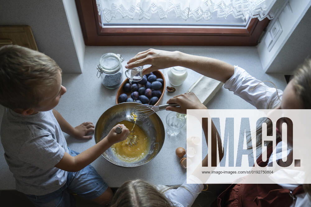 IMAGO Creative, Jahreszeit Sommer, Food, Pflaume Woman cooking cake of plums with children at home model released, Symbolfoto property released, NJAF00037