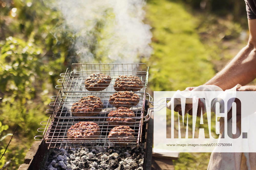 Hand s of man cooking burger patties in backyard model released, Symbolfoto, ONAF00097