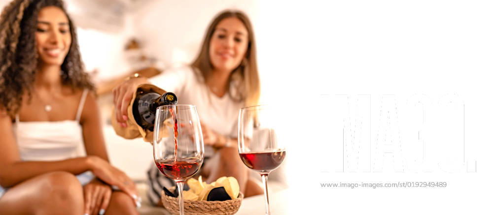 Two happy female friends celebrating at home pouring red wine in the glasses in selective focus effect and copy space. Young Caucasian woman toasting with her best Hispanic friend drinking alcohol, model released, , property released, , 35335182.jpg, glasses, friends, wine, red, people, home, happy, black, conversation, african-american, women, woman, african, american, young, toast, event, beautiful, birthday, glass, hand, party, summer, female, girlfriends, tasting, italy, drinking, girls, living, house, room, couch, apartment, attractive, comfortable, indoors, sofa, alcohol, cheers, girl, hipster, couple, lifestyle, reunion, meeting, leisure, person, latin, sitting